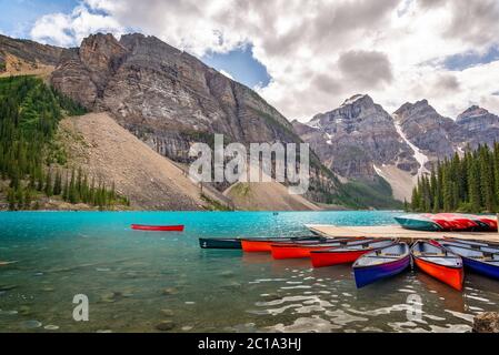 Canoe corlorenti sul lago Moraine vicino al villaggio di Lake Louise nel Parco Nazionale di Banff, Alberta, Montagne Rocciose, Canada Foto Stock