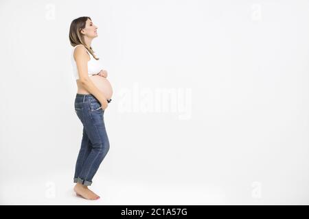 Bella donna incinta per interni su sfondo bianco Foto Stock