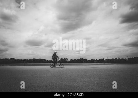 Una ciclista femminile durante il blocco del Covid-19 vicino a Hackney Marshes, Londra UK Foto Stock