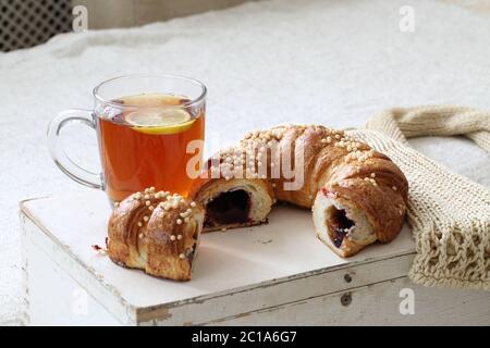 Torta Viennese riempito con le mele e le uve secche di Corinto e di una tazza di tè sul tavolo Foto Stock