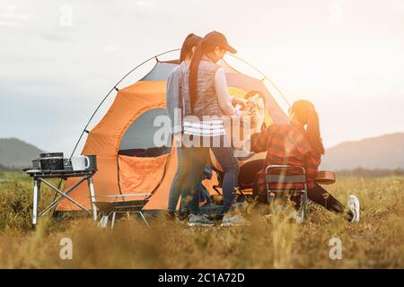 Gruppo di amici che si divertono insieme e bere al campeggio vicino al lago e rimbalziano. Foto Stock