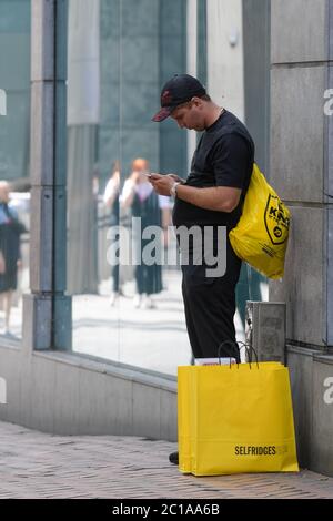 Birmingham, West Midlands, 15 giugno 2020. Un uomo si riposa dopo aver fatto acquisti a Selfridges, Birmingham, oggi, mentre migliaia di acquirenti si sono recati a Birmingham per acquistare articoli che hanno perso da quando i punti vendita sono stati chiusi durante il blocco COVID-19. Molti di loro erano in possesso di pacchetti di borse dopo un giro di shopping. Due uomini sono stati visti camminare lungo la New Street di Birmingham con sei borse Selfridges. Credito: Interrompi stampa Media/Alamy Live News Foto Stock