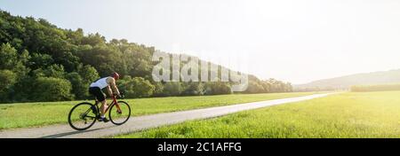 Panorama di ciclista in ciclo di corsa in un paesaggio rurale in estate con un'immagine panoramica delle lenti Foto Stock