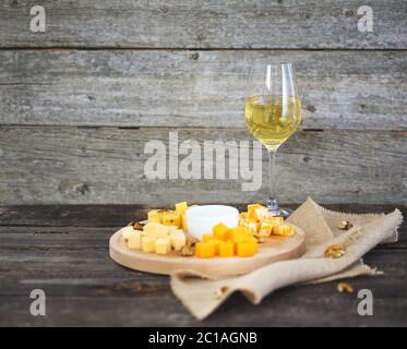 Insieme di formaggi di vario tipo con un bicchiere di vino bianco Foto Stock