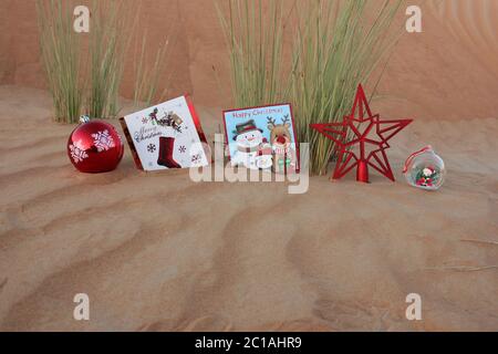 Oggetti a tema natalizio in una duna di sabbia del deserto rustica. Concetto per Natale/buone feste/Vacanze/Capodanno/festivo/sfondo del tema del festival. Foto Stock