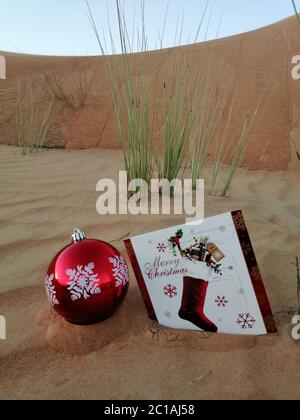 Oggetti a tema natalizio in una duna di sabbia del deserto rustica. Concetto per Natale/buone feste/Vacanze/Capodanno/festivo/sfondo del tema del festival. Foto Stock