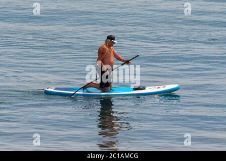 Lyme Regis, Dorset, Regno Unito. 15 giugno 2020. Regno Unito Meteo. Un paddle boarder sul mare godendo del caldo sole presso la località balneare di Lyme Regis in Dorset. Immagine: Graham Hunt/Alamy Live News Foto Stock