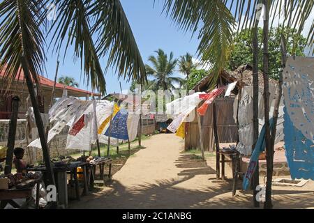 Tovaglie in vendita sospese in vendita sul marciapiede, Villaggio Ampangorinana, Isola Nosy Komba, Madagascar. Foto Stock