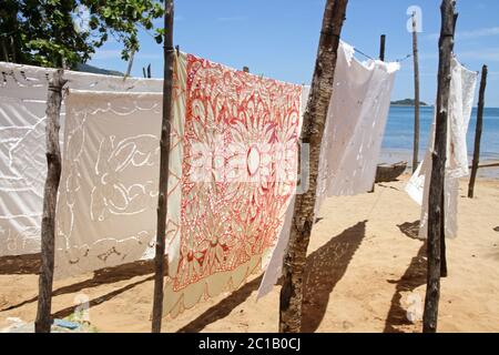 Tovaglie in vendita in vendita in spiaggia, Villaggio Ampangorinana, Isola Nosy Komba, Madagascar. Foto Stock