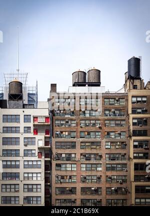 Vecchi edifici di appartamenti in mattoni con file di finestre nel centro di Manhattan New York City e cielo blu vuoto sopra Foto Stock