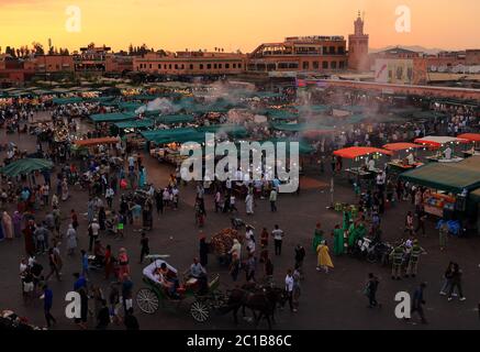 Marocco, Marrakech. Crepuscolo in Piazza Djemaa el Fna. Di notte la piazza si trasforma in un enorme ristorante all'aperto e in un'alveare di attività. Foto Stock