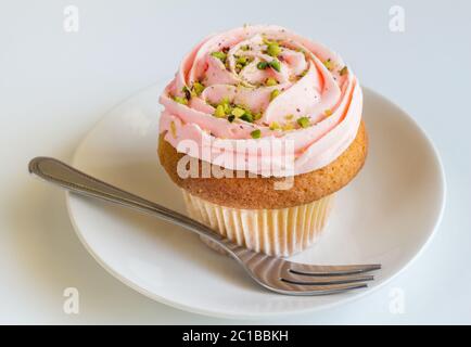 Rosa rosa roteato crema di burro vaniglia Cup cake su sfondo bianco Foto Stock