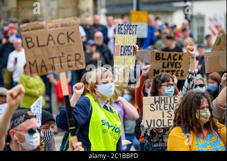 Richmond, North Yorkshire, UK - 14 giugno 2020: I manifestanti Black Lives Matter indossano maschere DPI e tengono cartelli fatti in casa ad una protesta BLM a Richmond, Foto Stock
