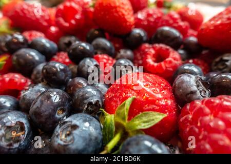 Primo piano con vista su frutti estivi, fragole, lamponi e mirtilli. Foto Stock