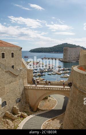 Porto e turisti visti attraverso le mura della fortezza a Dubrovnik, Croazia Foto Stock