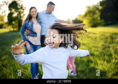 Felice famiglia con due piccole figlie che si divertono all'aperto nella natura primaverile. Foto Stock