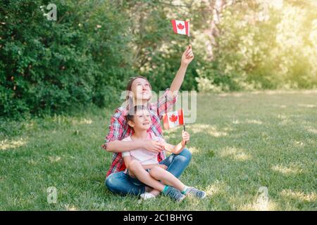 Mamma di famiglia con figlio che festeggia la festa nazionale del Canada il 1 luglio. Madre caucasica con bambino che sventolava bandiere canadesi. I cittadini fieri festeggiano Foto Stock