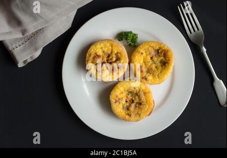 Quiche Lorraine backround, vista dall'alto di tre mini tortine closeup sulla tavola nera Foto Stock