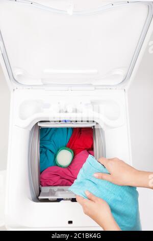 Macchina di lavaggio caricata con i vestiti. Foto Stock