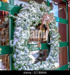 Cornice quadrata corona smerigliata sulla parete di vetro dell'edificio che riflette il paesaggio invernale Foto Stock