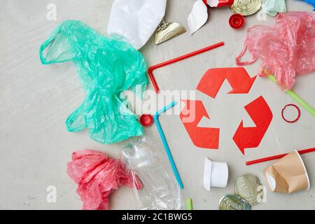 Primo piano delle confezioni intorno al simbolo rosso di riciclaggio isolato su sfondo grigio Foto Stock