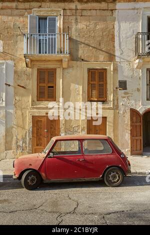 Vecchia auto d'epoca di fronte alla tipica casa tradizionale a la Valletta a Malta Foto Stock