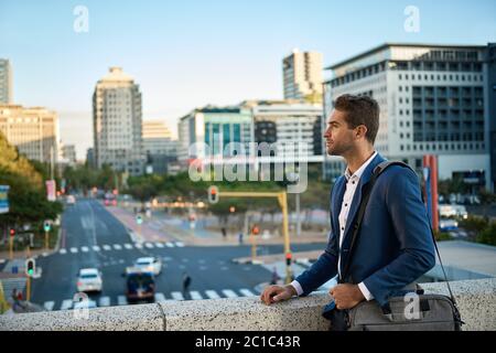Giovane uomo d'affari che cammina per la città per lavorare Foto Stock