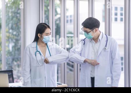 I medici di sesso femminile e maschile toccano il gomito per salutarsi a vicenda.nuovo concetto di saluto normale Foto Stock