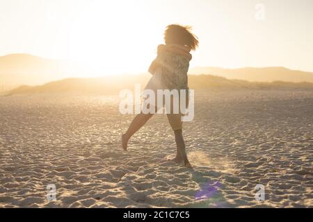 Un uomo afro-americano che raccoglie la donna in un momento romantico Foto Stock