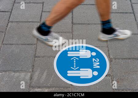 Cartello stampato a terra che informa le persone di mantenere una distanza di 2 metri l'una dall'altra durante la pandemia di Covid-19. Foto Stock