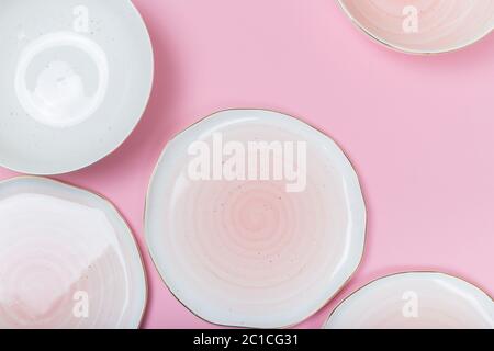 Piatti e ciotole vuoti su sfondo rosa. Vista dall'alto con spazio per la copia Foto Stock