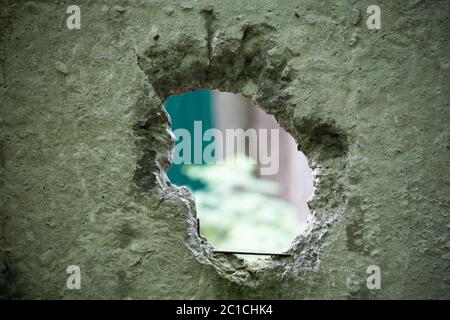 Buco nel muro di cemento Foto Stock