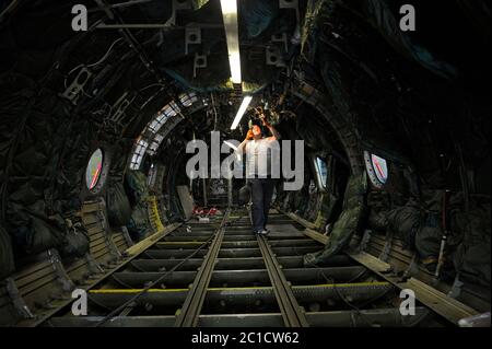 Operatore che installa un nuovo cablaggio elettrico all'interno di un piano della carrozzeria. L'impianto di riparazione di aeromobili di Stato 410 Foto Stock