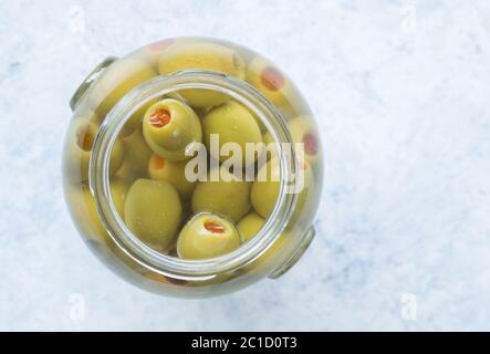 Vaso di olive verdi ripiene in salamoia close up top view foto con copia spazio per il testo Foto Stock