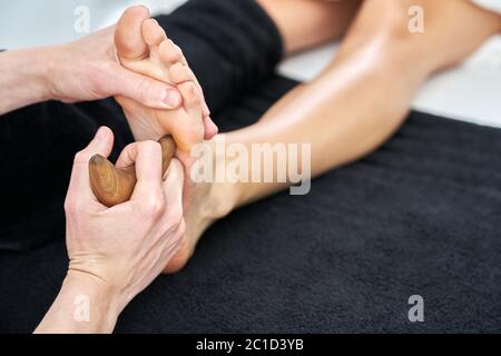 Immagine di una donna che si gode massaggio tailandese piedi in salone professionale Foto Stock