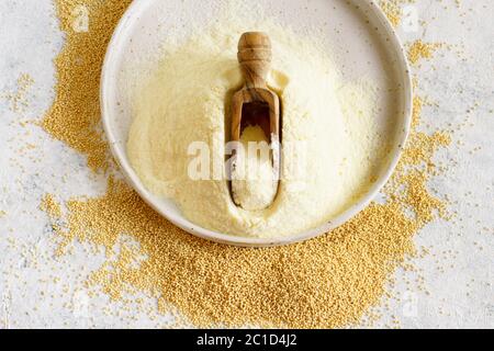 Piatto di farina di Amaranto cruda con un cucchiaio e semi di Amaranto su tavola bianca vista dall'alto Foto Stock