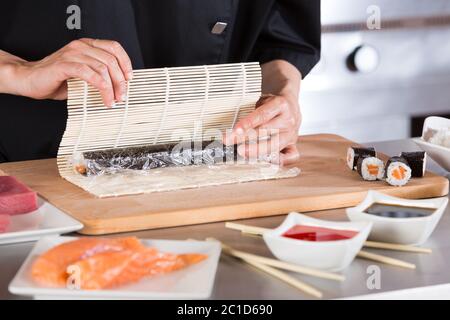 Chef che prepara deliziosi sushi in un ristorante Foto Stock