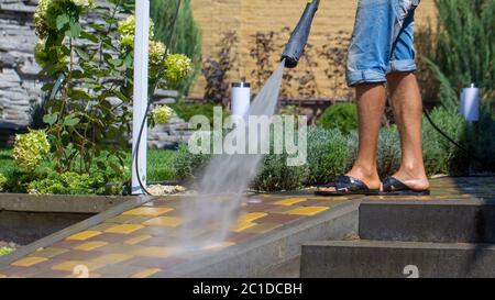 Uomo di lavaggio percorso concreto con la rondella di pressione Foto Stock