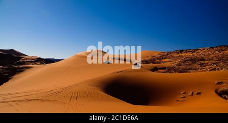 Vista al tramonto sulla duna di Tin Merzouga con auto al parco nazionale di Tassili nAjjer, Algeria Foto Stock