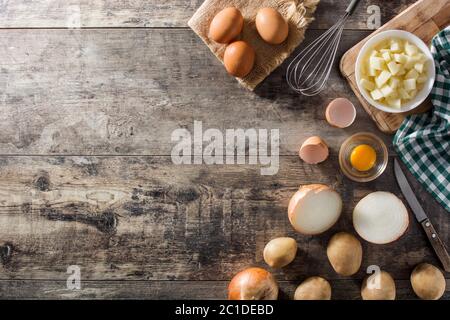 Tortilla alle omelette spagnole ingredienti: Uova, patate e cipolla su tavola di legno Foto Stock