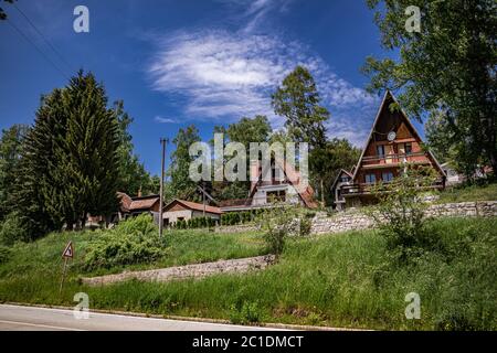 Lago Vlasina, Serbia - Giugno 14. 2020 Case in resort week-end con tetti spioventi tradizionali e strada di campagna, la foresta intorno alle case Foto Stock