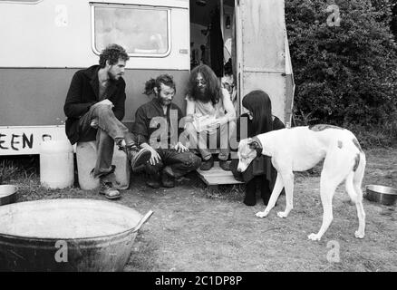 Un gruppo di viaggiatori chiacchiera fuori dalla propria roulotte in un sito vicino a Stonehenge all'inizio degli anni '90. REGNO UNITO. Foto Stock