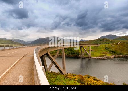 KYLESKU BRIDGE SUTHERLAND SCOTLAND SOPRA LOCH CAIRNBAWN CON FIORI GIALLI DI GOLA SULLA BANCA Foto Stock