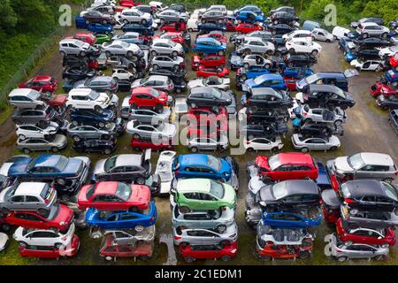 Vista aerea di molte auto immagazzinate in un cantiere di demolizione di auto o rottami in Scozia, Regno Unito. Foto Stock