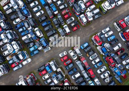 Vista aerea di molte auto immagazzinate in un cantiere di demolizione di auto o rottami in Scozia, Regno Unito. Foto Stock