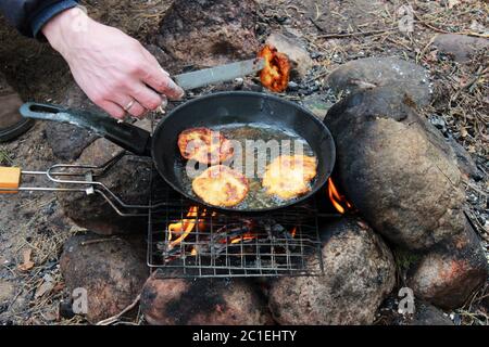 Cucina cena sul fuoco in padella di ghisa. foto barbecue Foto stock - Alamy