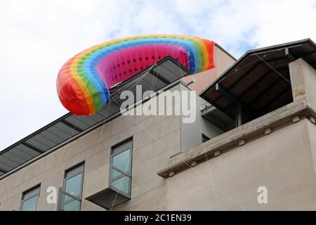 Londra, Regno Unito. 15 giugno 2020. Il mercato di Covent Garden ha volato un arcobaleno sopra il mercato famoso in tutto il mondo 'riconoscendo il ruolo del simbolo di speranza riconosciuto a livello mondiale negli ultimi tempi, e accogliendo i londinesi di ritorno in città, mentre i negozi di tutta la capitale iniziano ad aprirsi' dopo il blocco di Coronavirus. Purtroppo, mentre veniva abbassata dai lavoratori, si impigliava negli edifici opposti. Fortunatamente i lavoratori qualificati sono riusciti a liberarlo prima di riportarlo a terra. Credit: Paul Brown/Alamy Live News Foto Stock