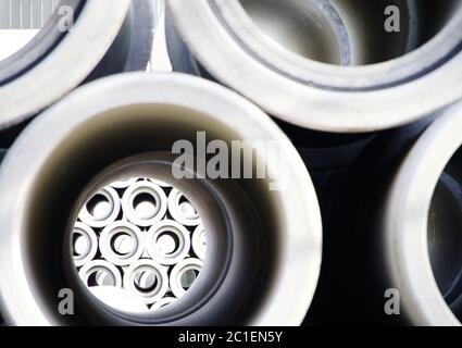 Guardando attraverso un tubo su tubi di calcestruzzo impilati Foto Stock