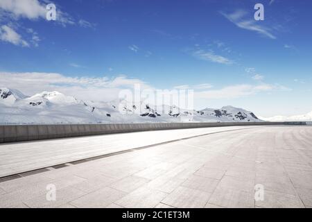 terra di mattoni vuota con montagna sonw come sfondo Foto Stock