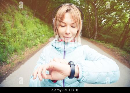 Ritratto giovane donna di fitness guardando il suo orologio intelligente mentre si prende una pausa da allenamento sportivo. Impulso di controllo sportivo ON Foto Stock